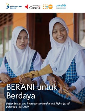 Two Indonesian school girls wearing hijab smile with string instruments in their hands